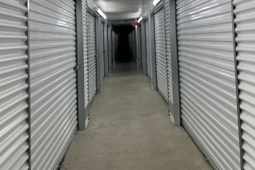 A construction worker using a power drill on a building site, outdoors during the day.