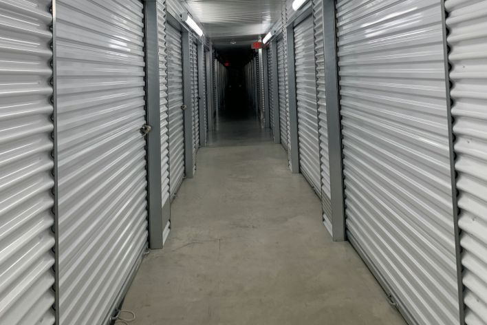 A construction worker using a power drill on a building site, outdoors during the day.